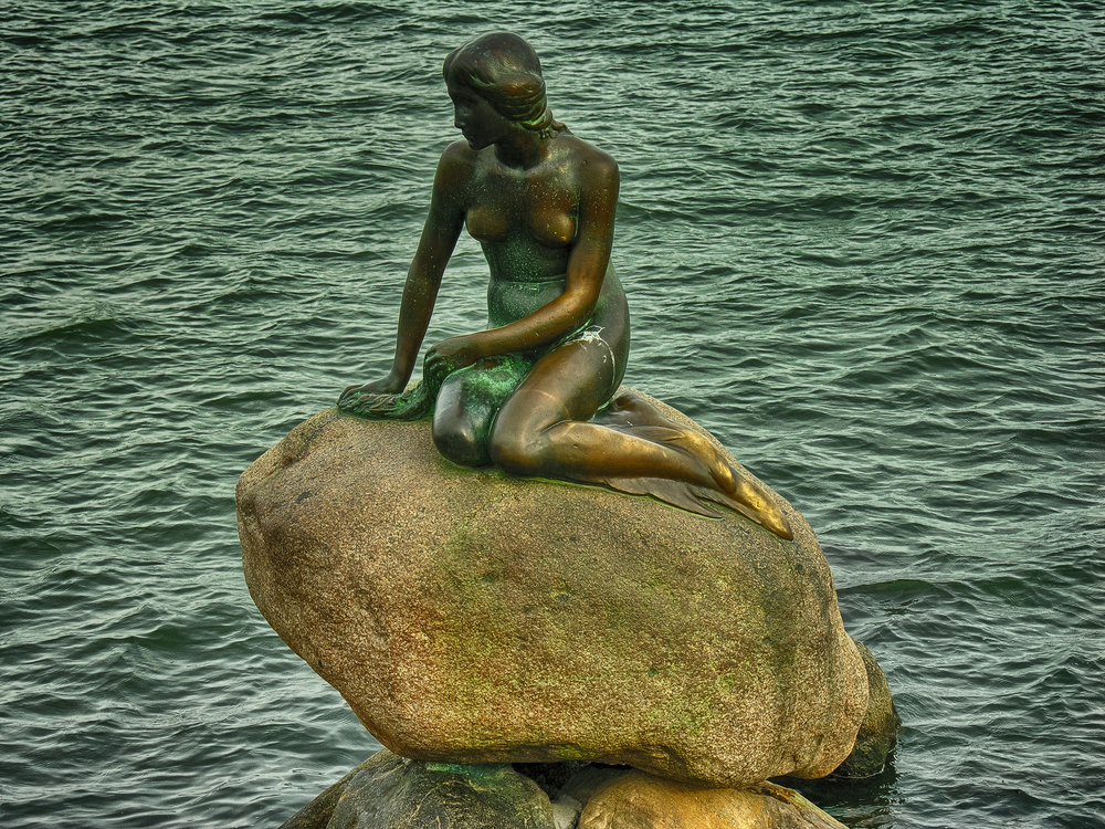 Little Mermaid statue sitting on a rock on the harborfront in the northern Kastellet area on August 11 2008 in Copenhagen Denmark