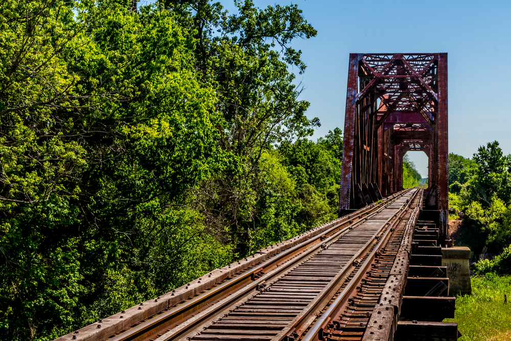 An Old Railroad Trestle with an Old Iconic Iron Truss Bridge Over the Brazos River Texas