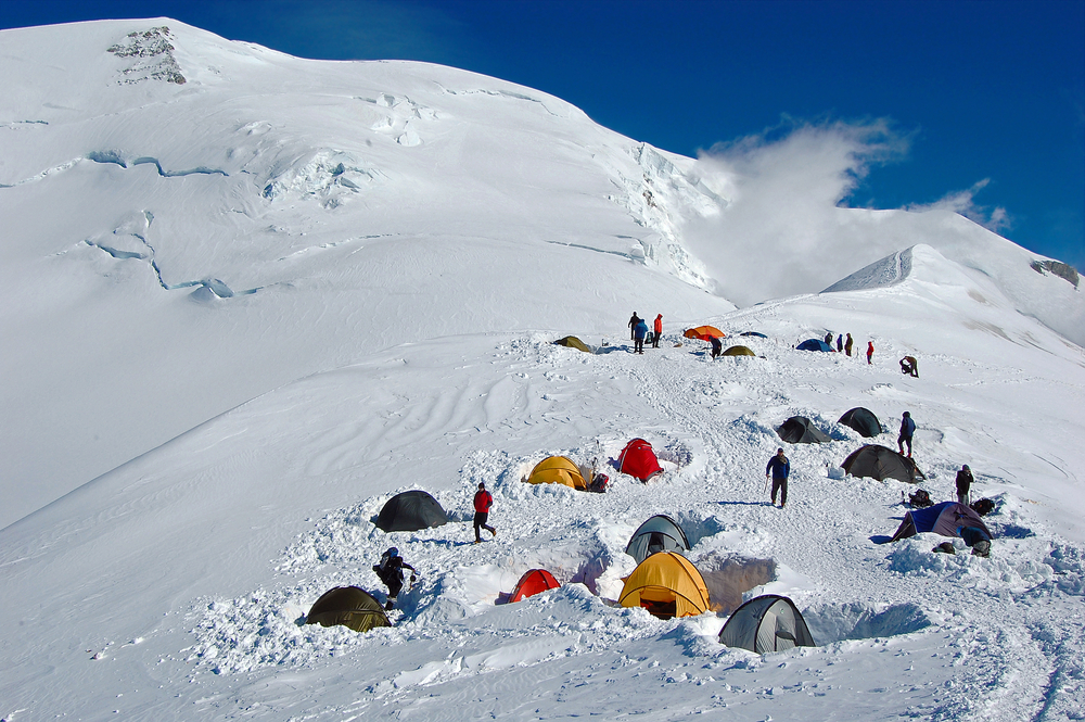 Colorful tents in high snowy mountains Refuge du Goater halfway up Mont Blanc in France 