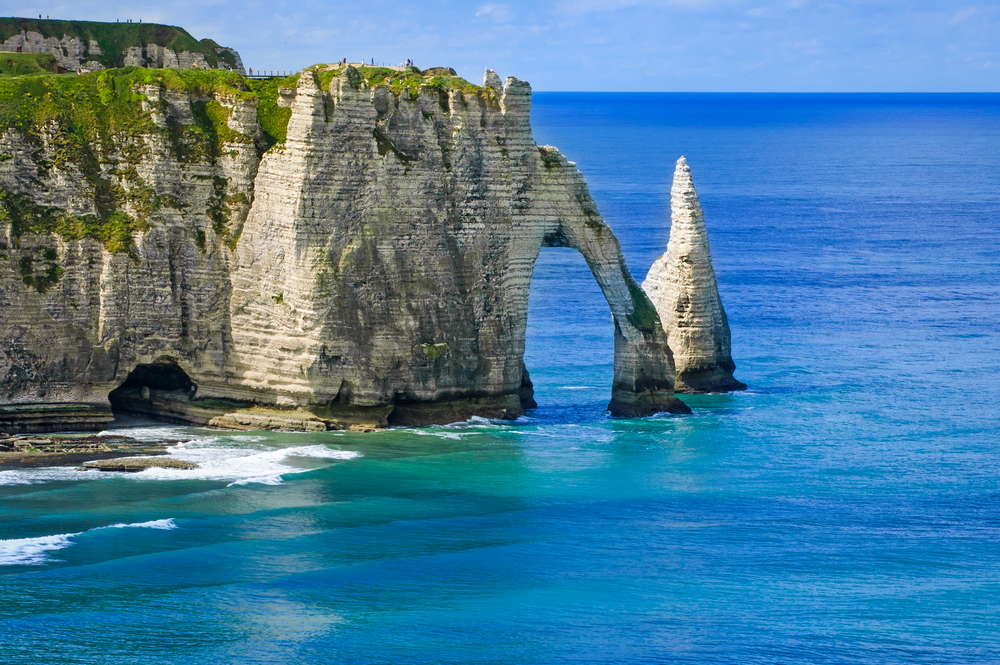Etretat Aval cliff rocks and natural arch landmark and blue ocean