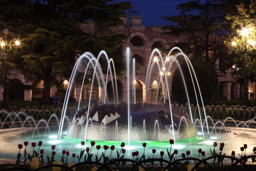 Fountain in front of the ancient roman amphitheatre in Verona Italy at night 
