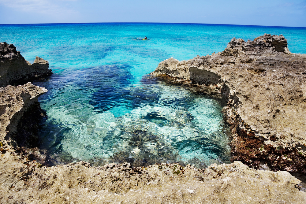Man explores the reef off the rocky Ironshore formation areas of Smith Cove Grand Cayman