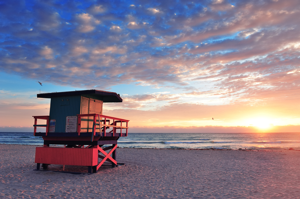 Miami South Beach sunrise with lifeguard tower and coastline with colorful cloud and blue sky