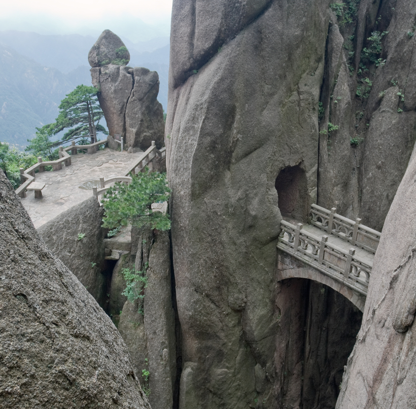 Mountain stone bridge above rocky precipice between the rock