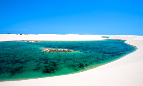 view of lagoa azul in desert white sand dunes of the Lencois Maranheses National Park in brazil 